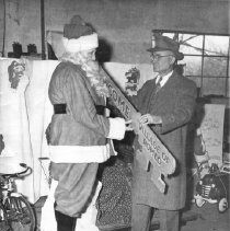 Village President, Jewel E. West, presents Santa with the key to the Villag